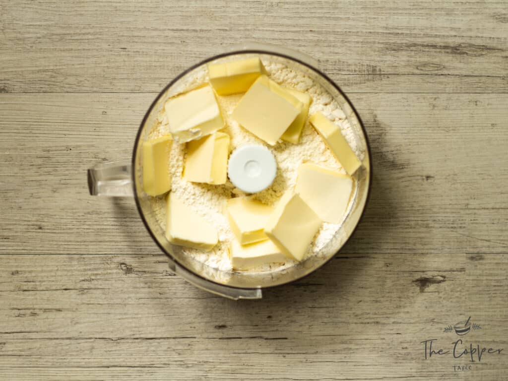 Flour and butter in the food processor about to be pulsed