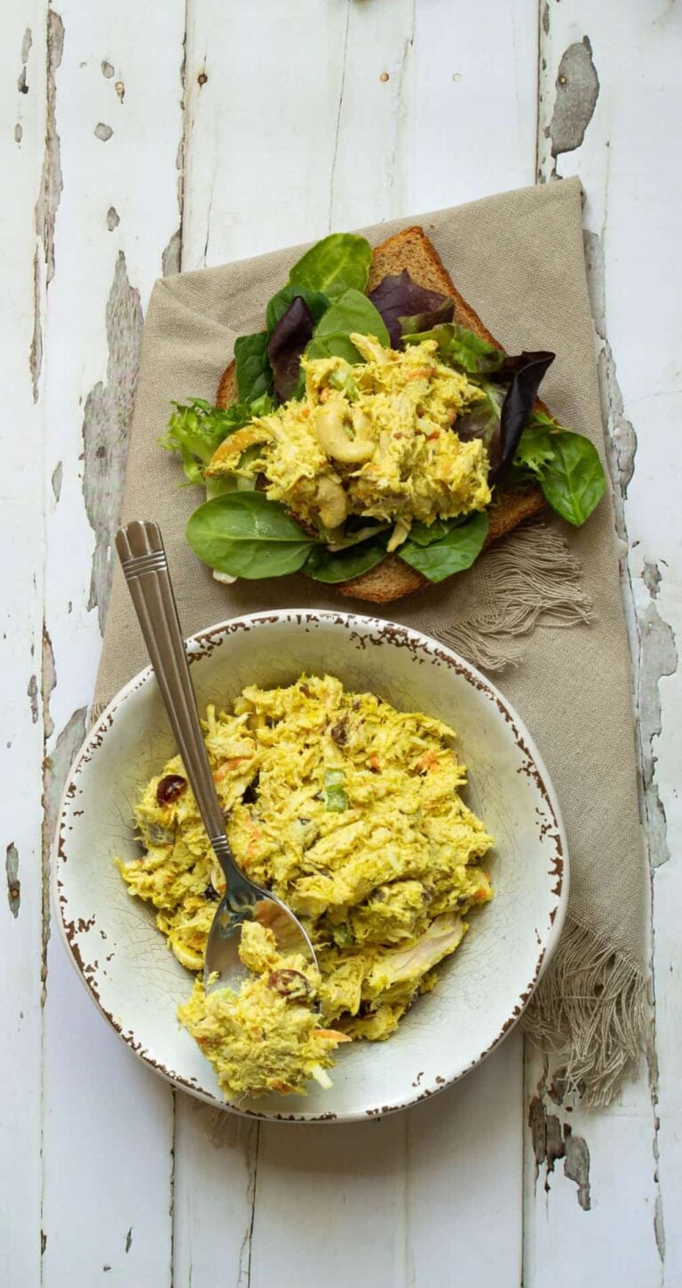 scoop of chicken salad on bread next to a bowl