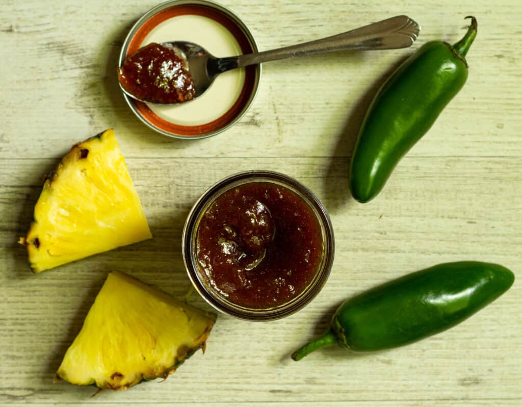 overhead view of barbeque sauce with pieces of fresh pineapple and jalapeno