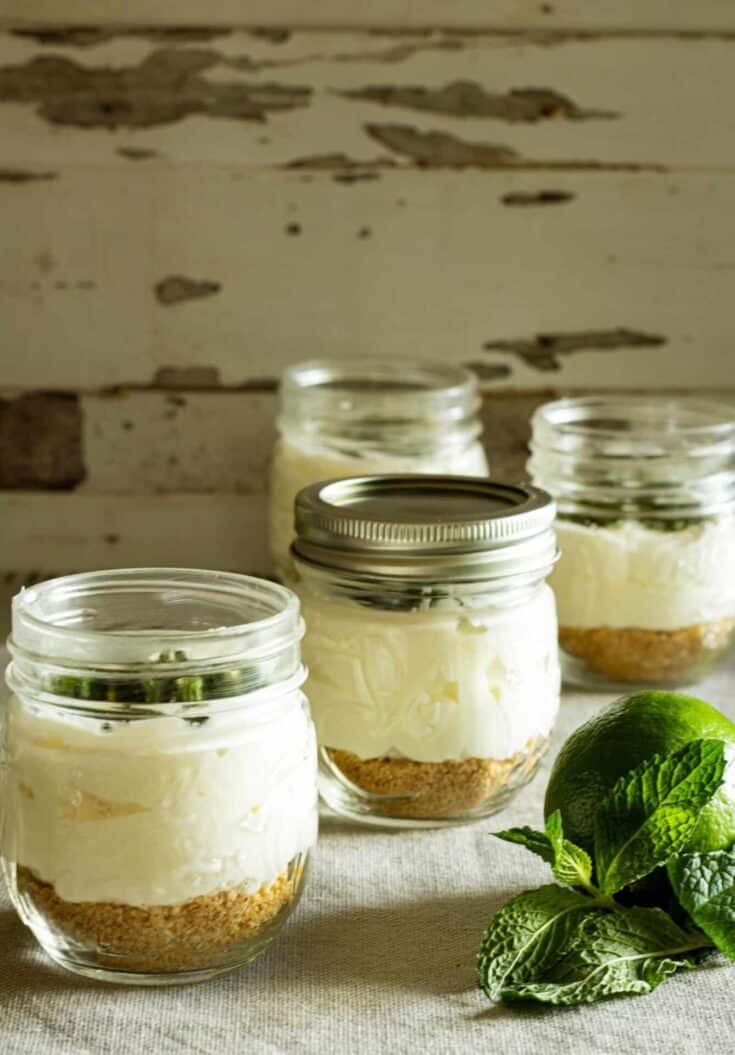 jars of no bake chhesecake with a lime and fresh mint