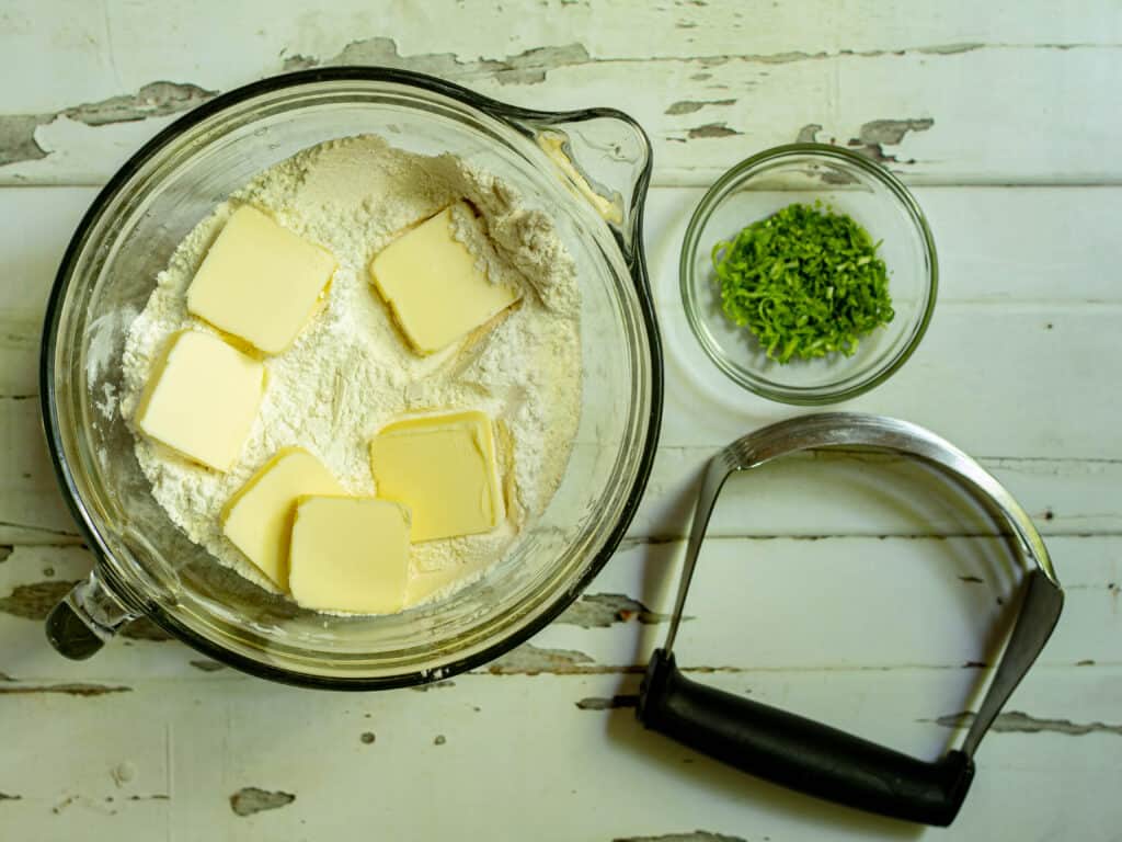 bowl of flour with butter in the bowl and lime zest