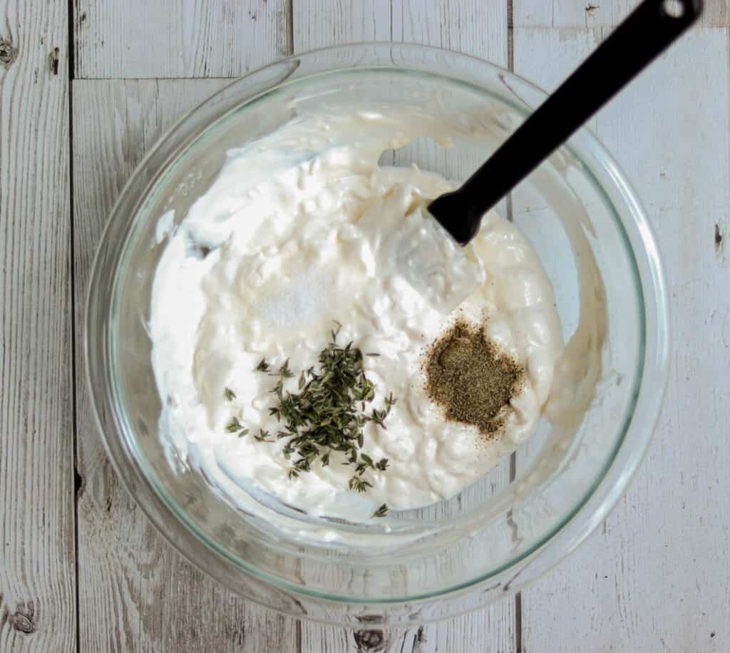 bowl with cream cheese mixture and salt, pepper, and fresh thyme