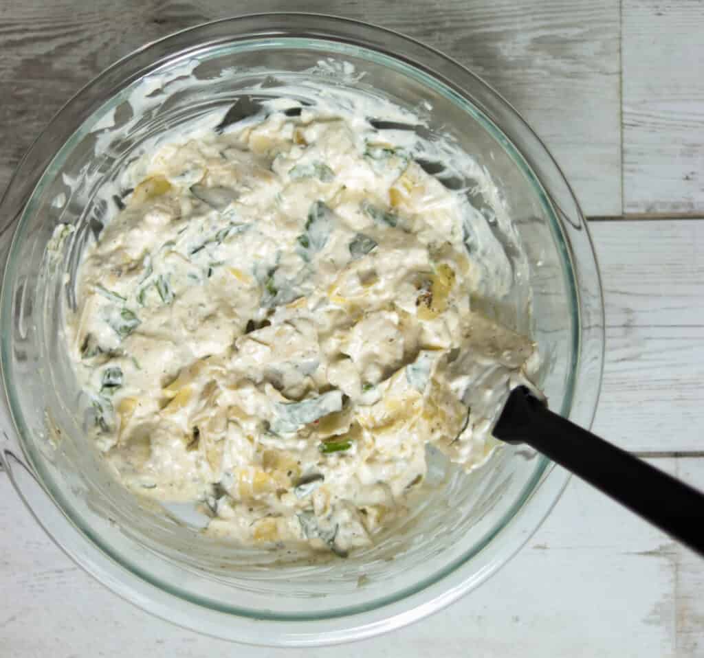 artichoke dip in a bowl ready to bake