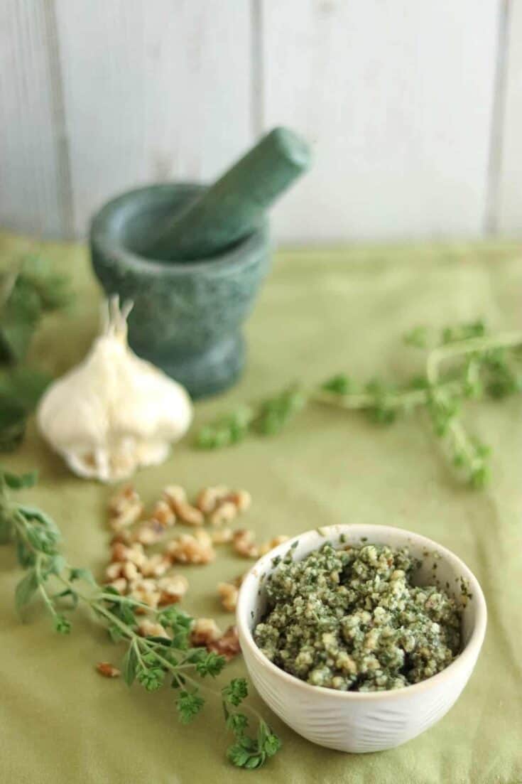 pesto with ingredients on a green background