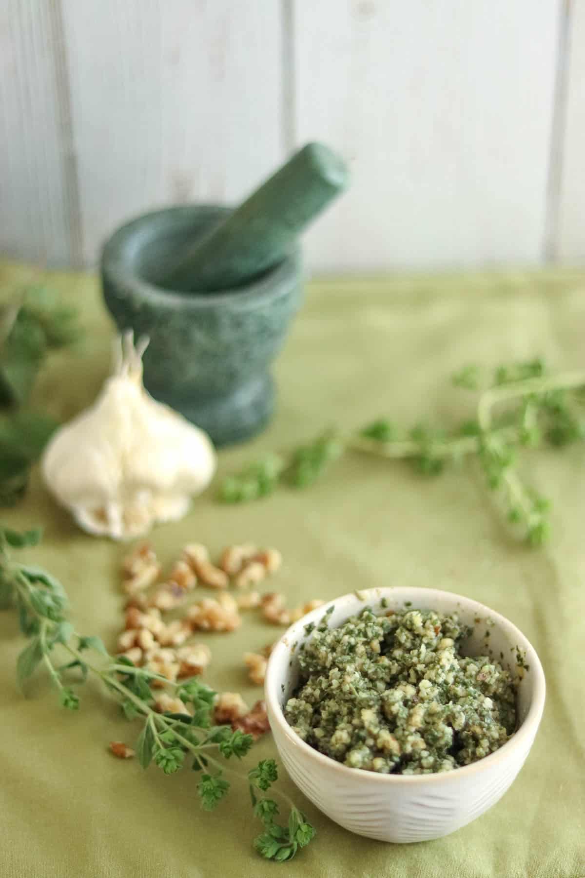 pesto with ingredients on a green background