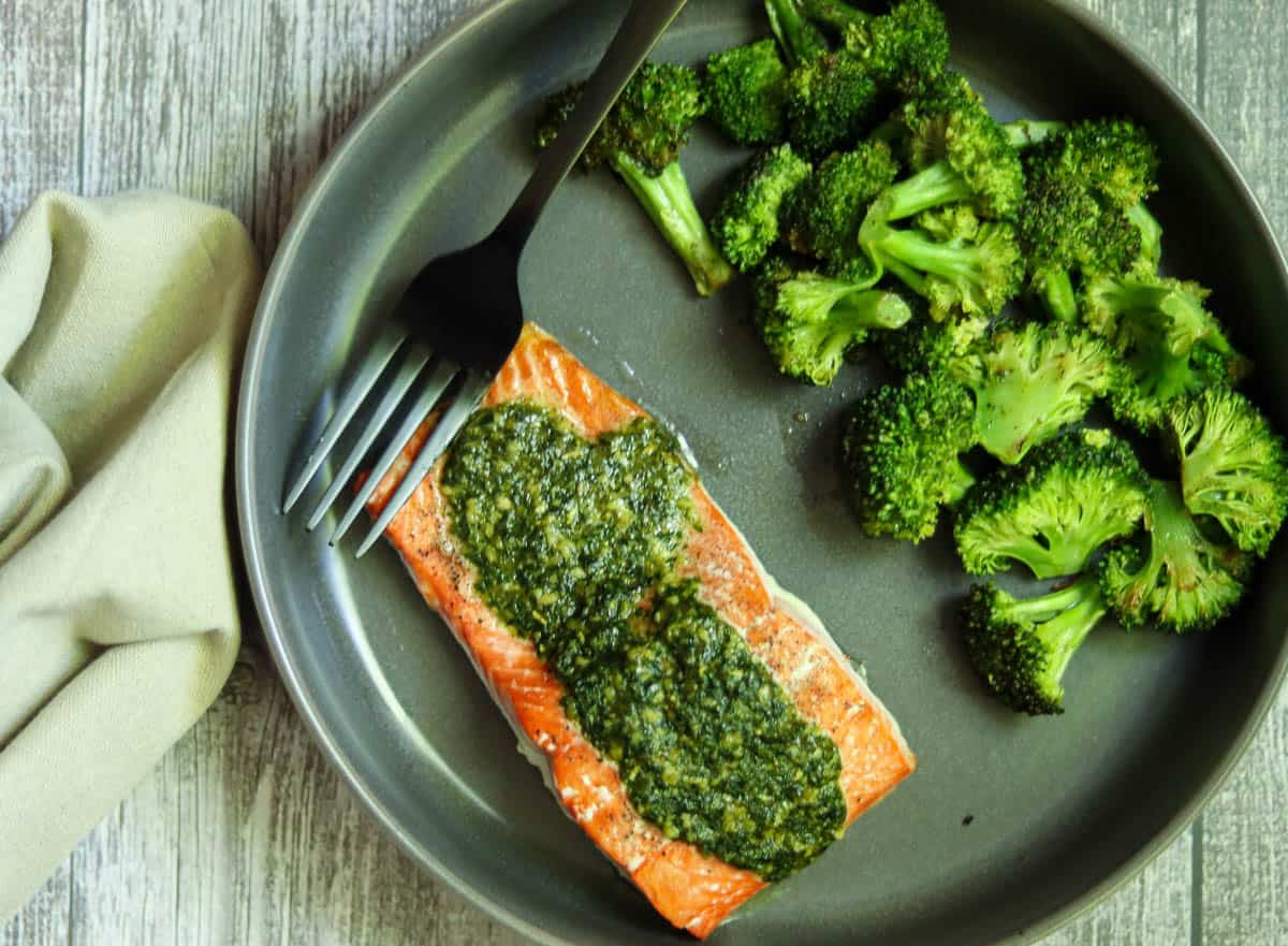 pesto butter salmon with a fork and napkin.