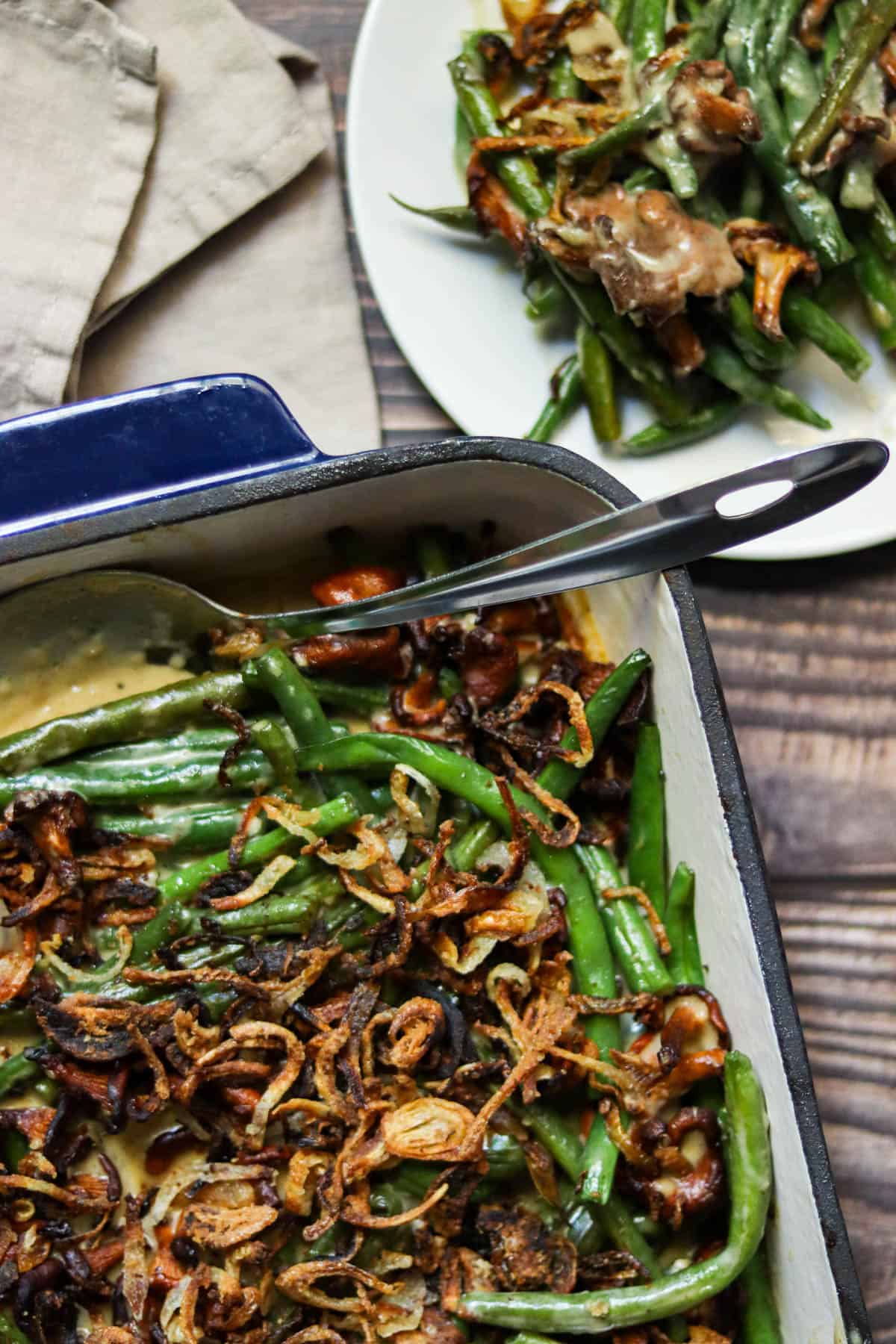 green bean casserole in a dish next to a plate.