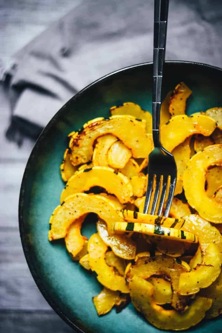 Delicata squash cooked in an air fryer in a blue bowl.