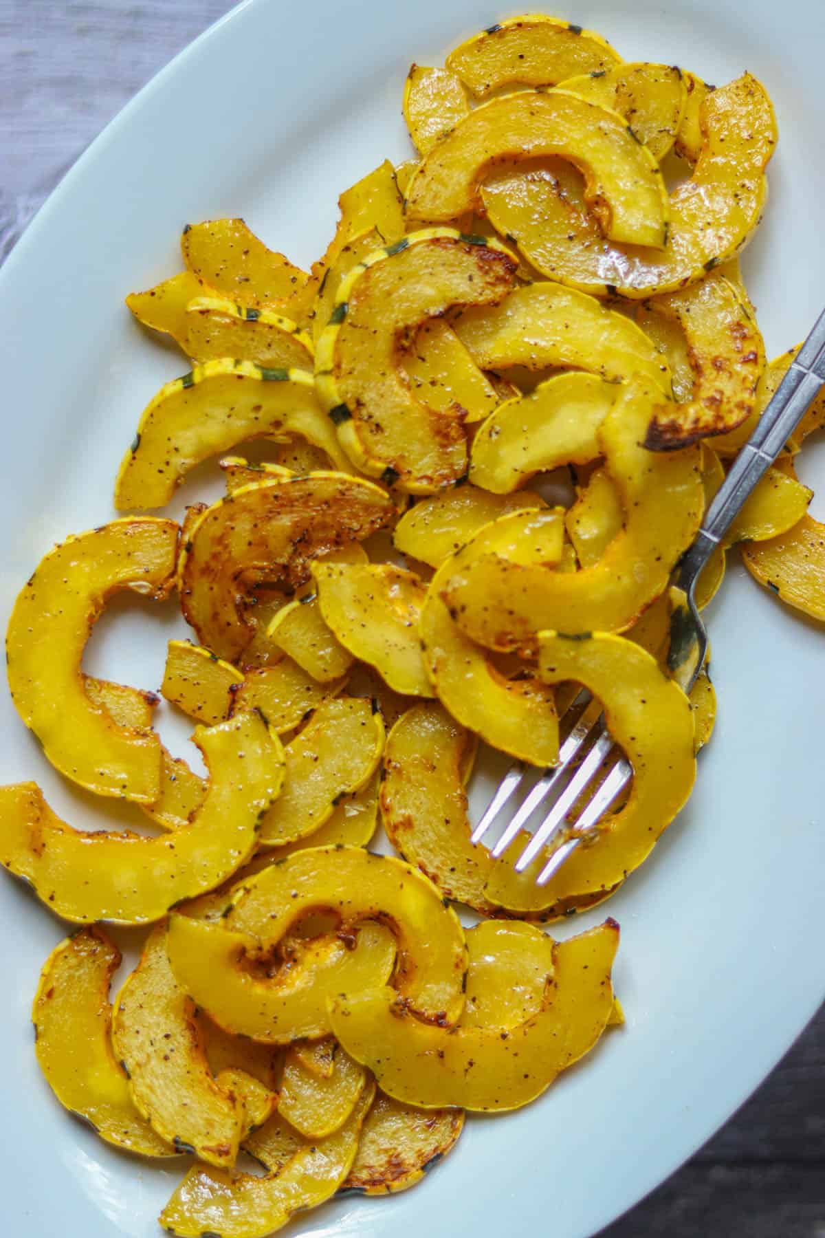 Air fried Delicata Squash on a white plate with a fork.