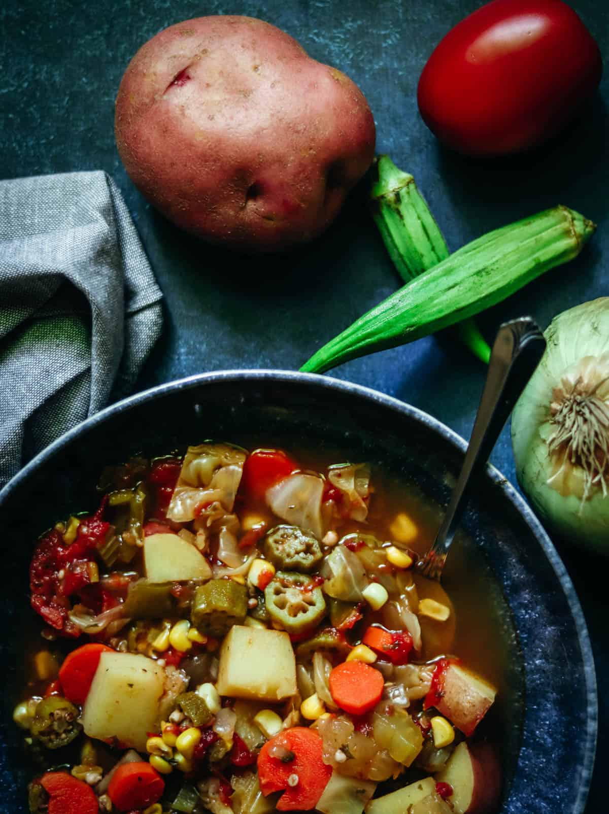 Bowl of vegetable soup on a blue background.