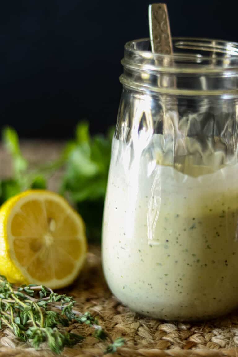 Photo of lemon herb tahini sauce on a brown woven placemat.