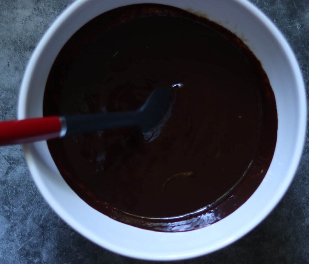 Adding the melted chocolate to the wet ingredients.
