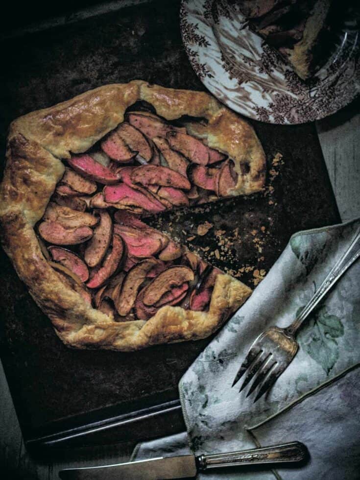Whole galette on a baking sheet with a slice removed.