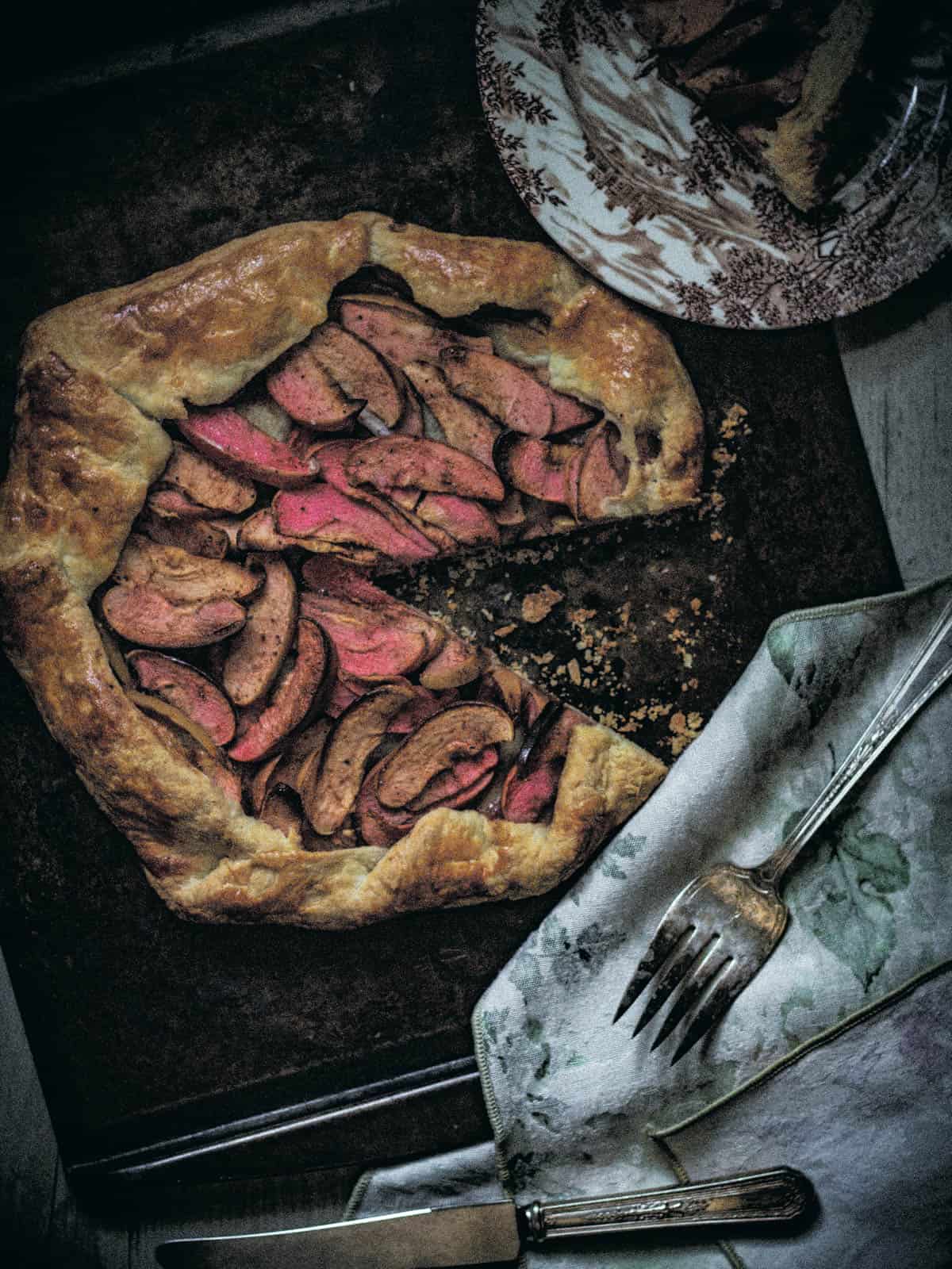 Whole galette on a baking sheet with a slice removed.