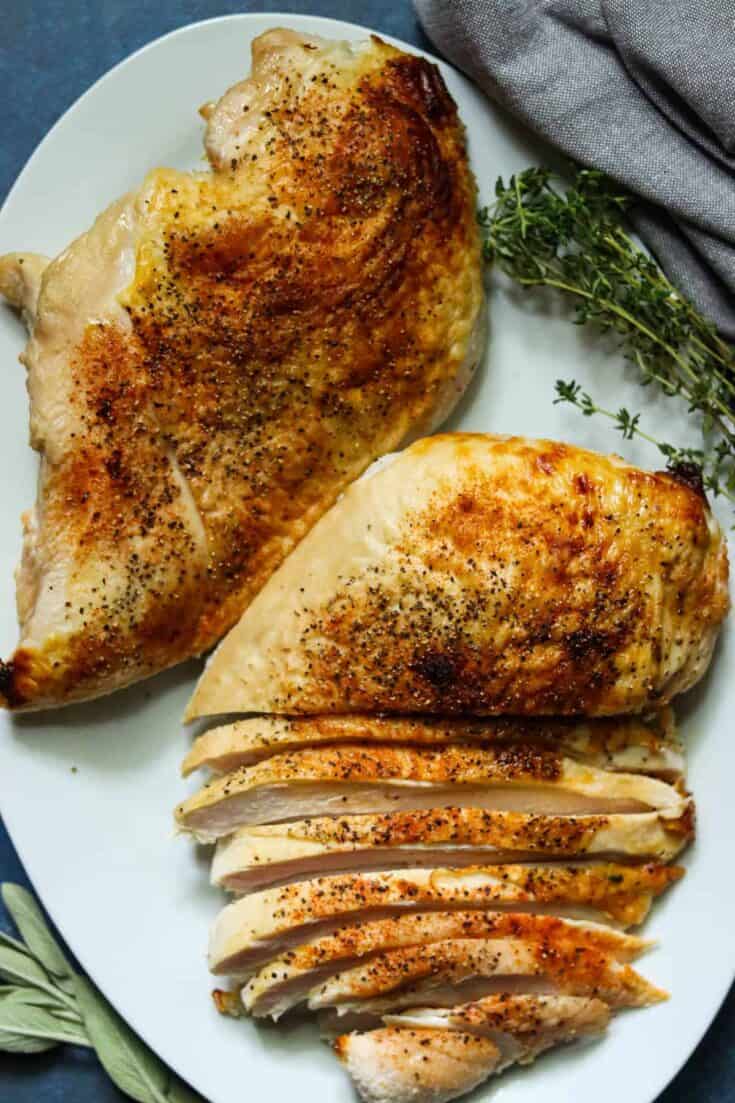 Two buttermilk brined turkey breasts on a white plate.