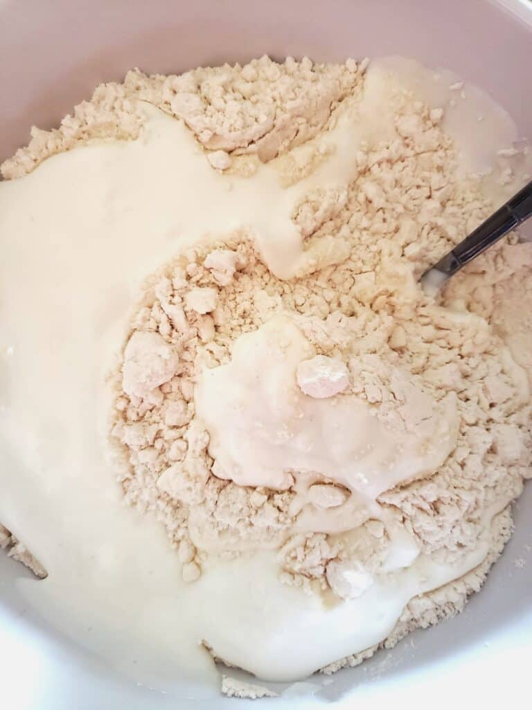 Adding the liquid ingredients to the dry ingredients.