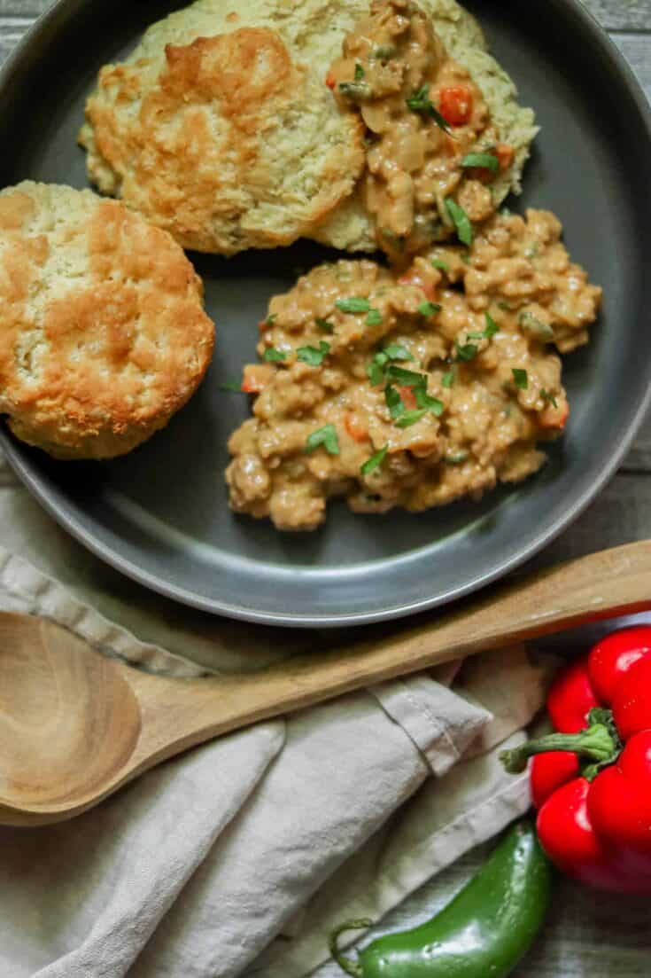 Chorizo biscuits and gravy on a gray plate.