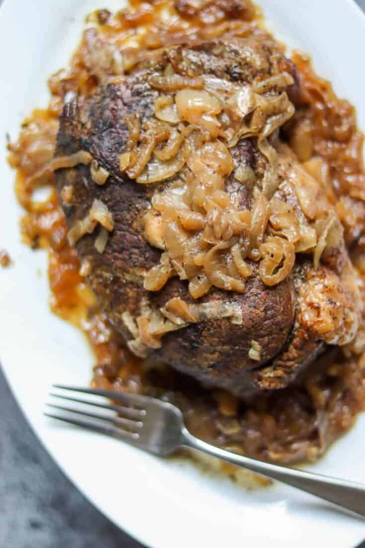 Pot Roast with onions on a white plate.