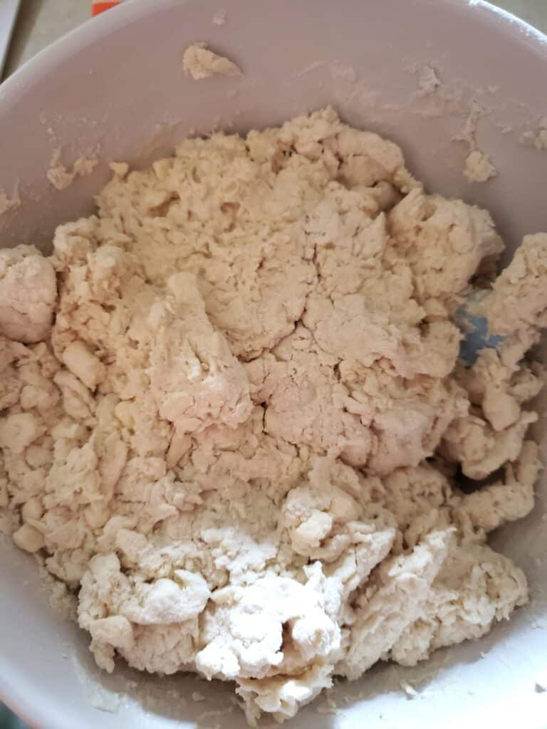 Stirring the liquid into the dry ingredients for biscuits.