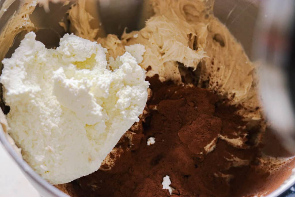 Adding the cocoa powder and ricotta cheese to the mixer.