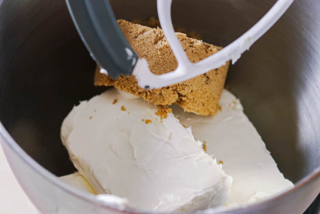 Brown sugar and cream cheese in a mixer bowl.
