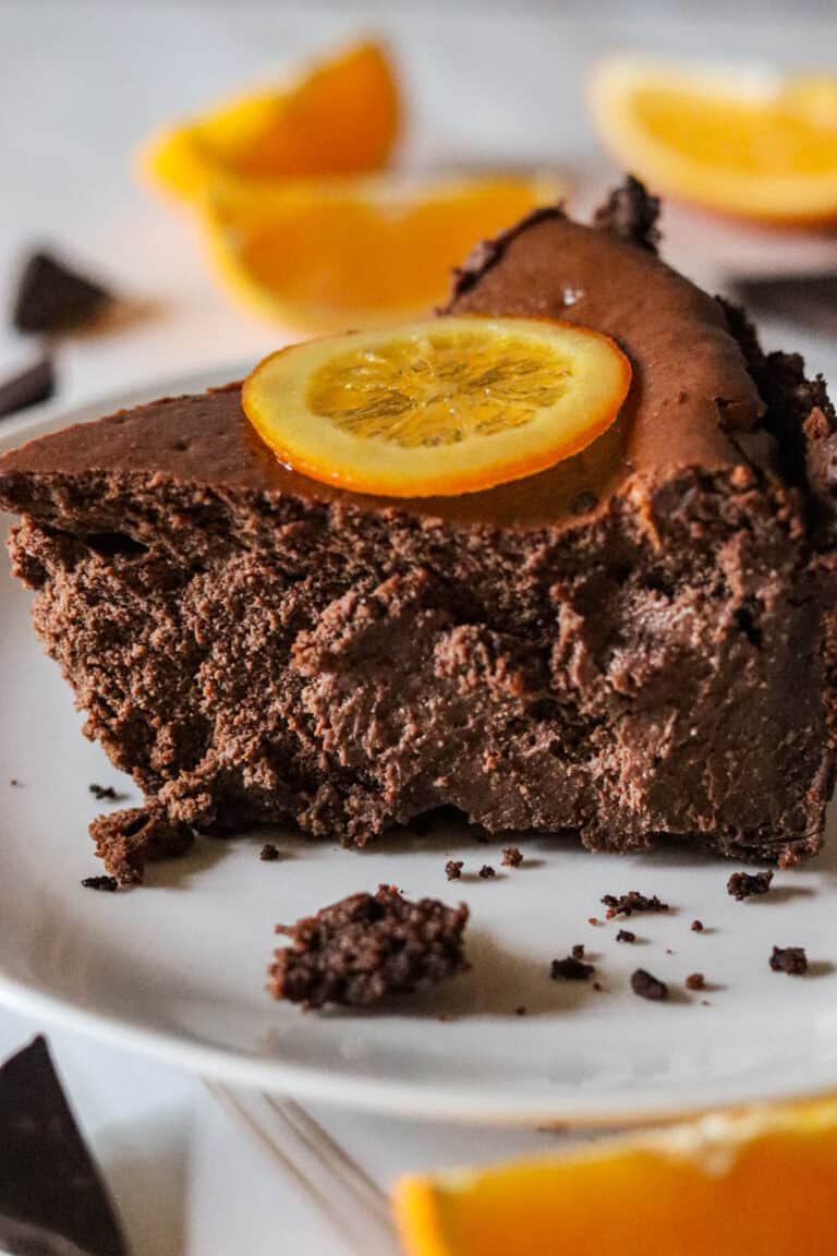 Slice of chocolate orange cheesecake on a white plate.