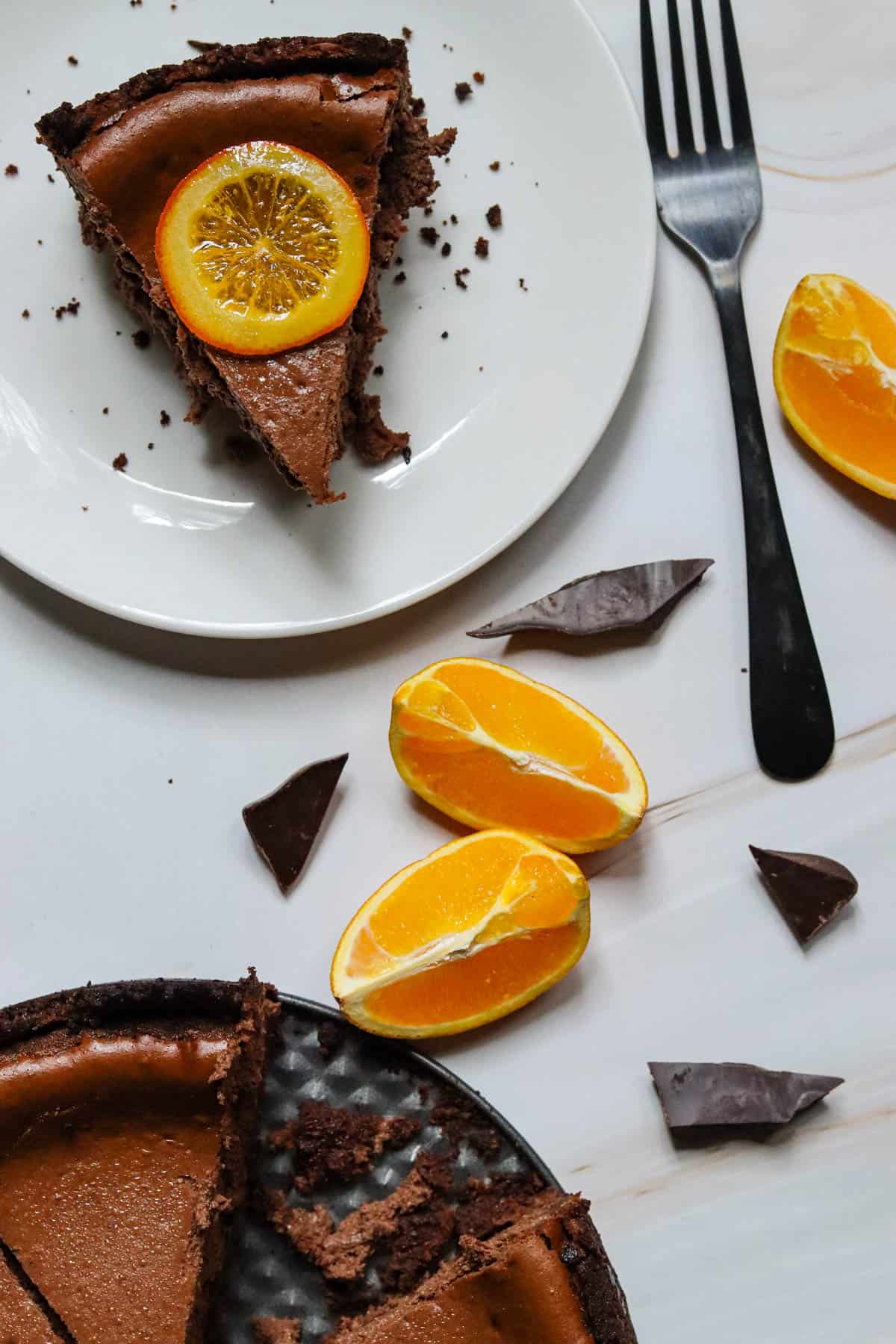 Slice of chocolate orange cheesecake next to the springform pan.