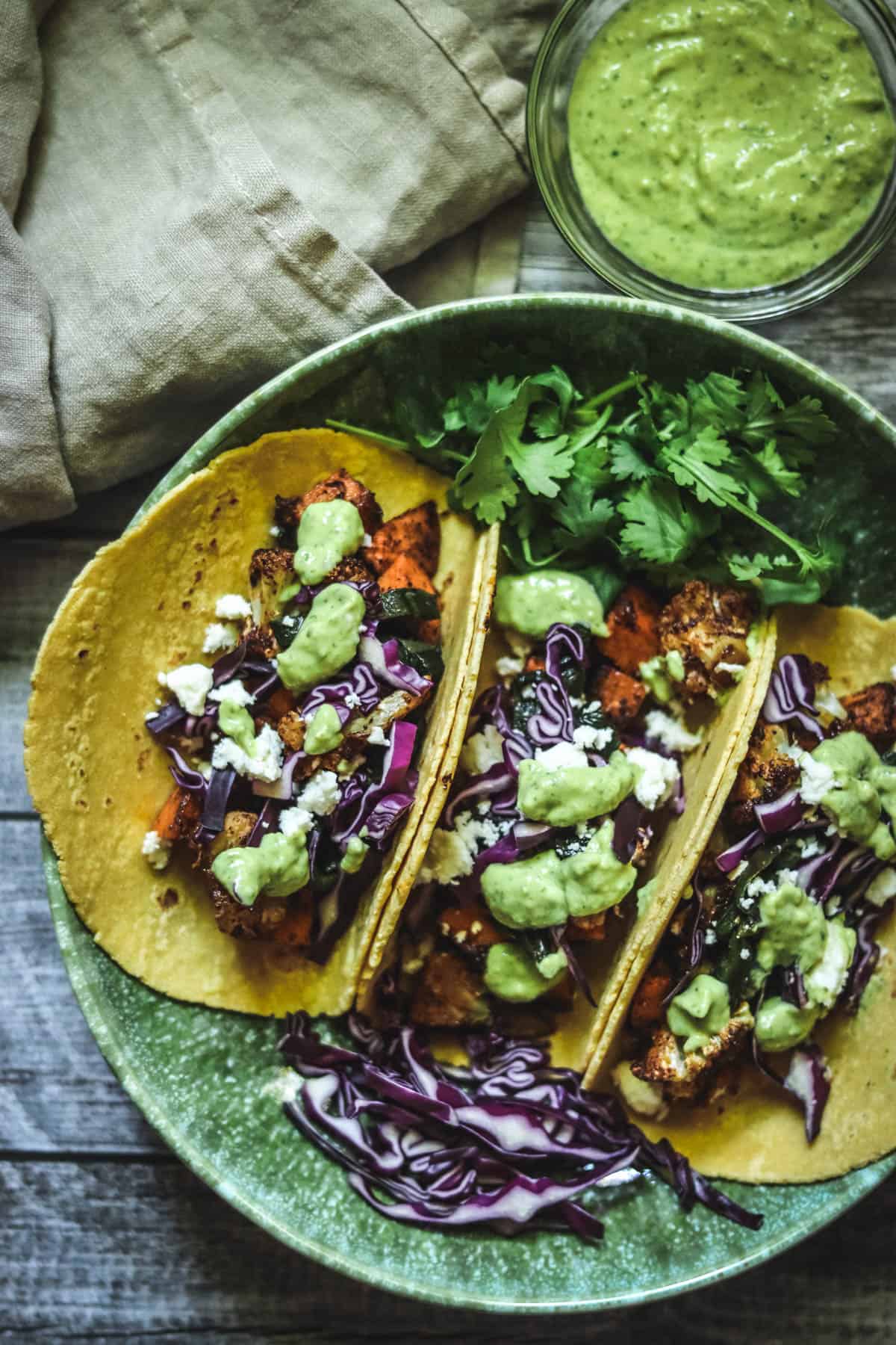 Three sweet potato tacos with a napkin.