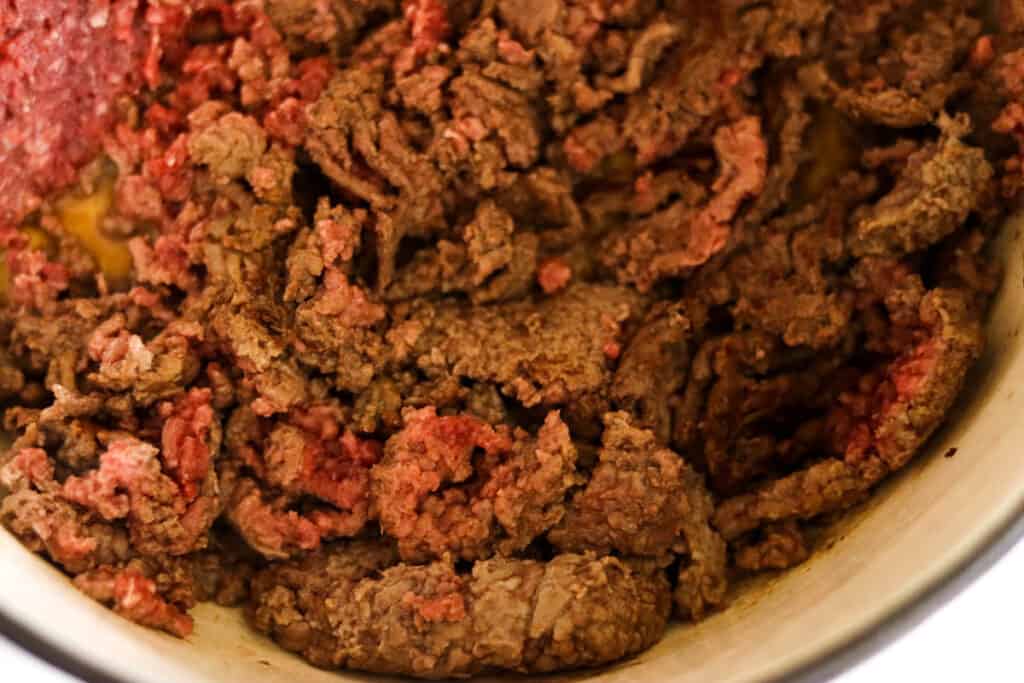 Ground beef browning in a Dutch oven.