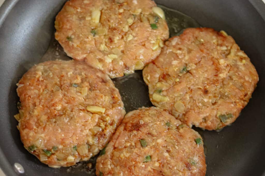 Burger patties in a skillet.