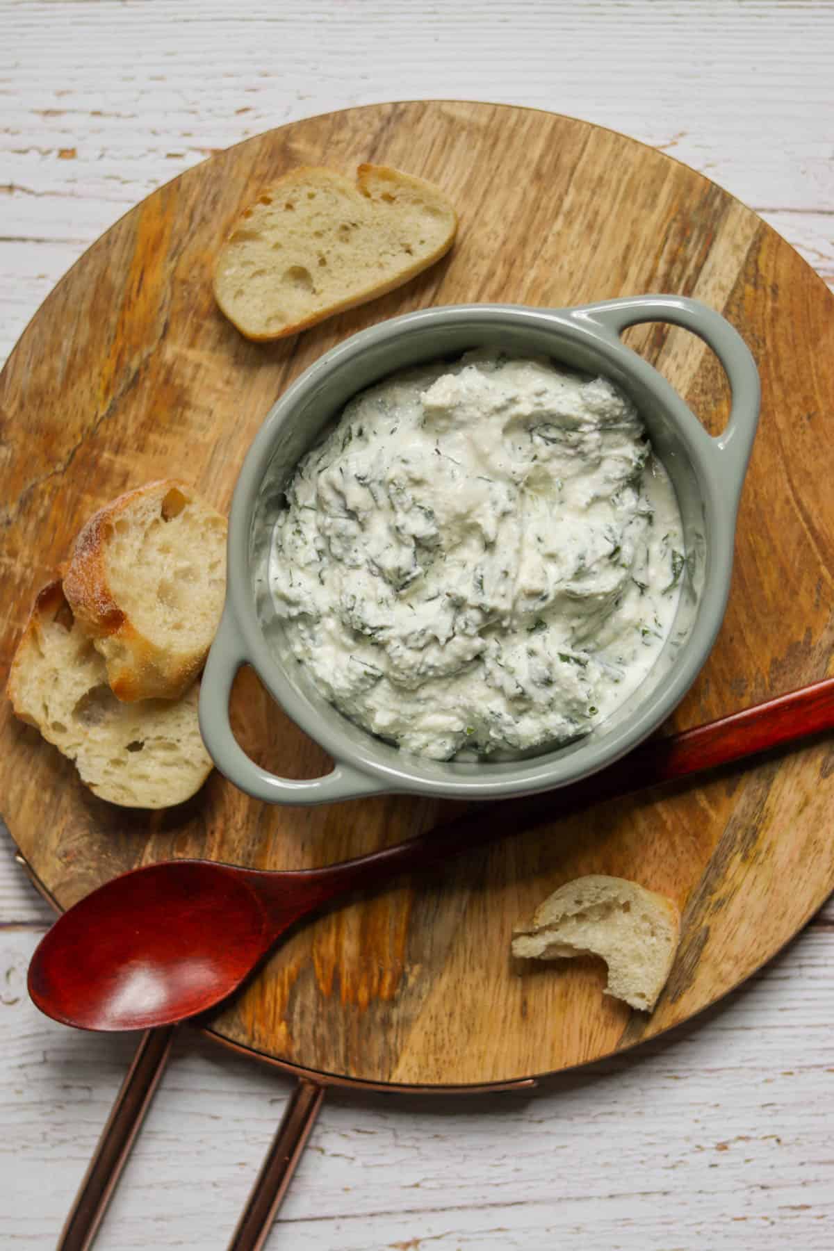 Gray dish of green goddess dip with a wooden spoon.