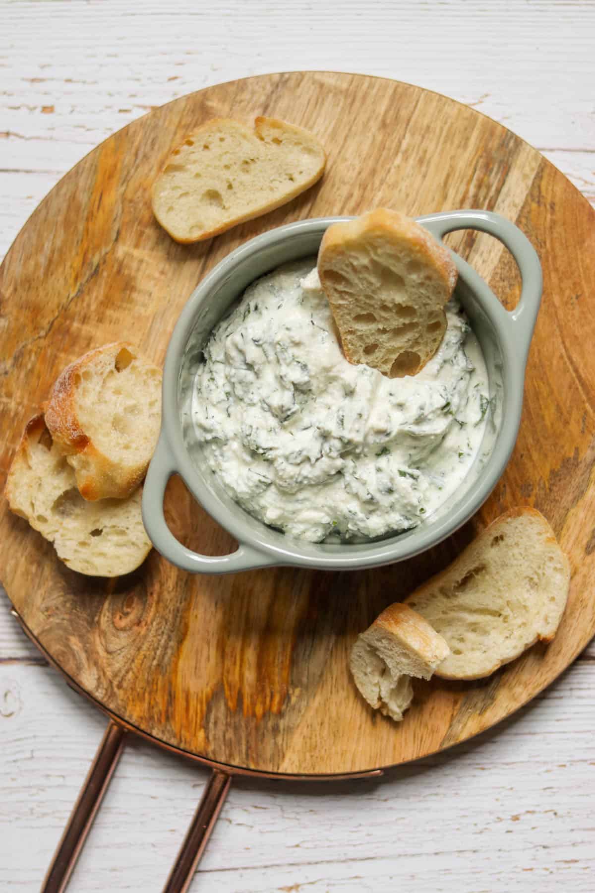 Green Goddess dip in a dish with baguette slices.