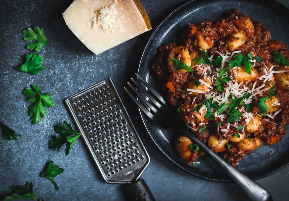 Gnocchi Bolognese on a blue plate.