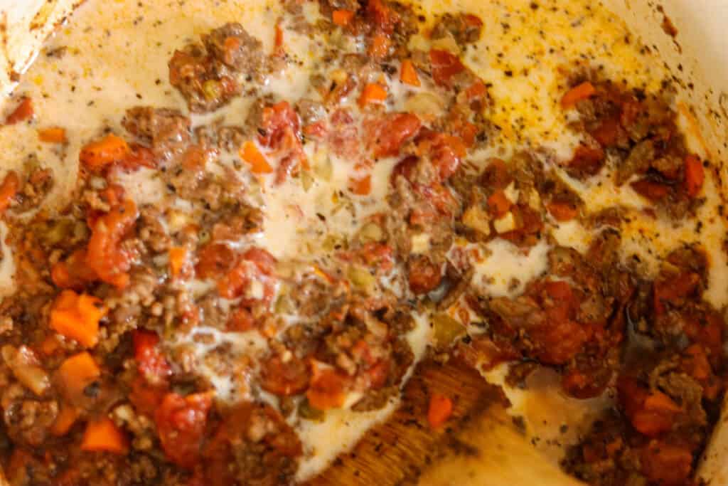 Whole milk being poured into the sauce.