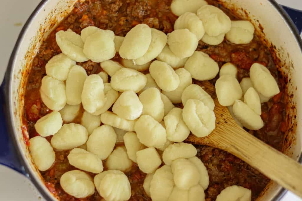 Gnocchi being added to the sauce.