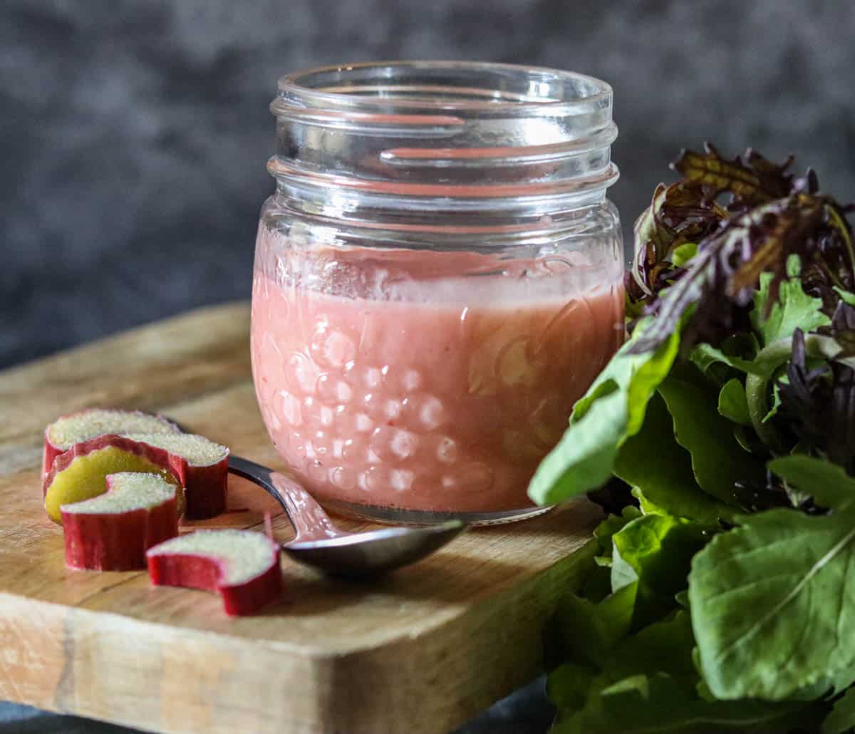 rhubarb vinaigrette in a glass jar on a wooden board.