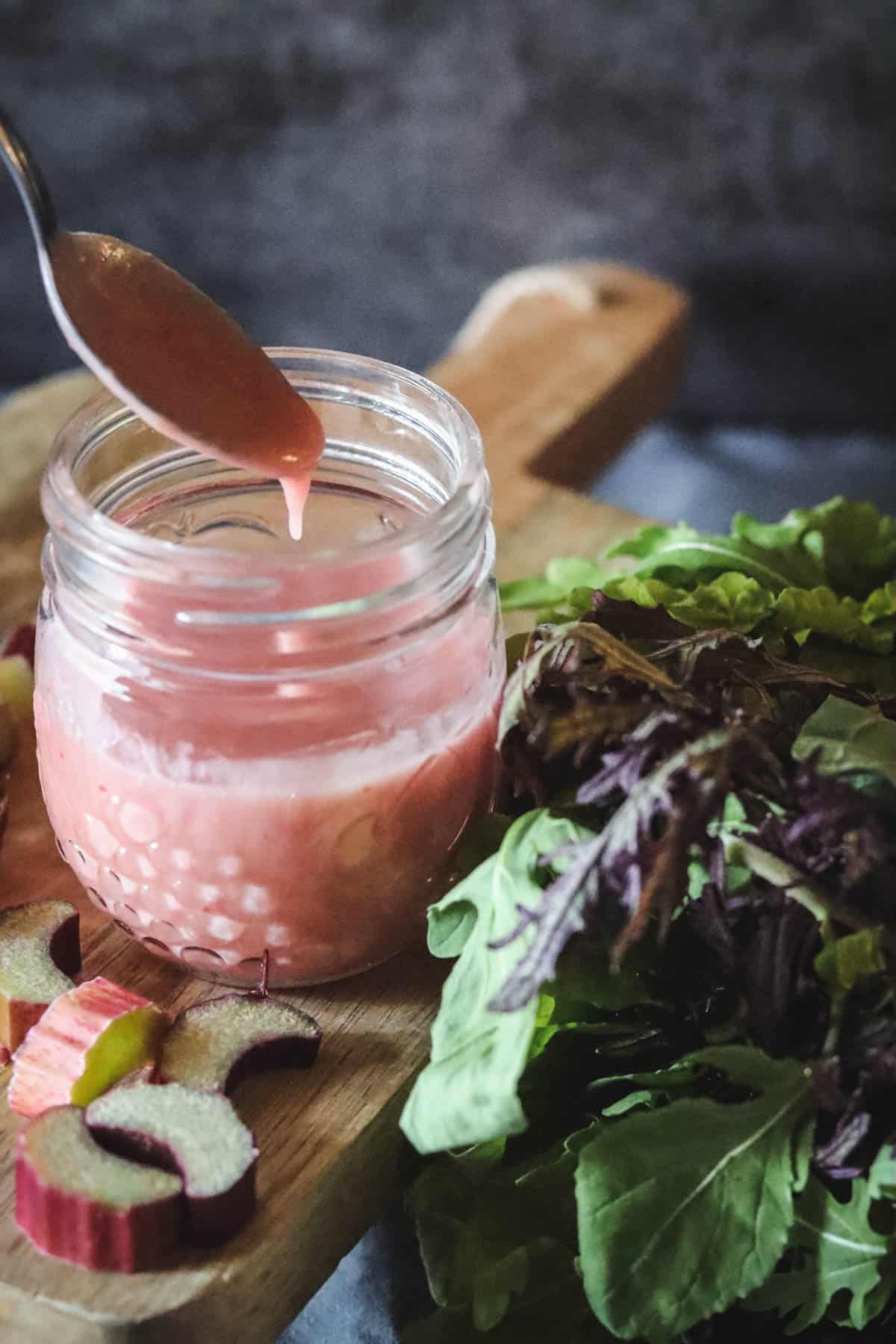 Rhubarb dressing with salad greens and sliced rhubarb.