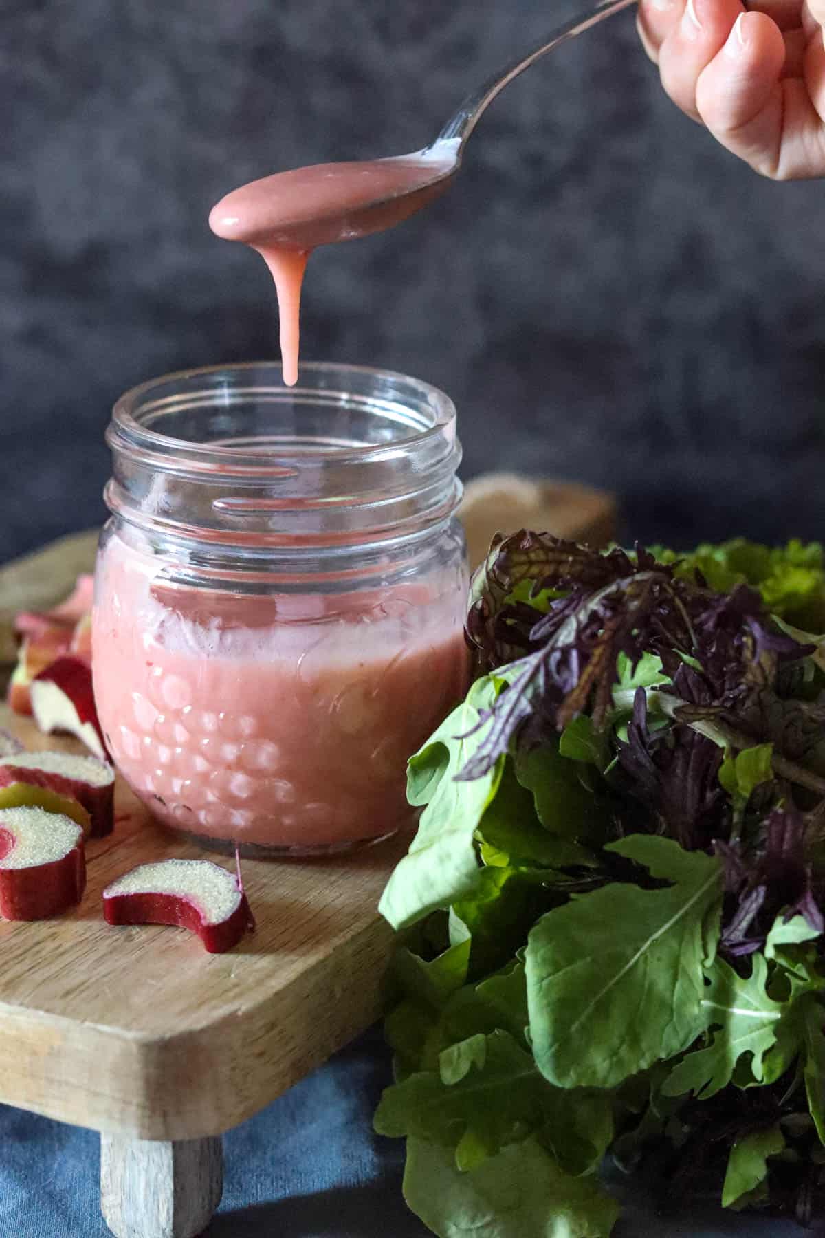 Jar of rhubarb vinaigrette with a spoon.