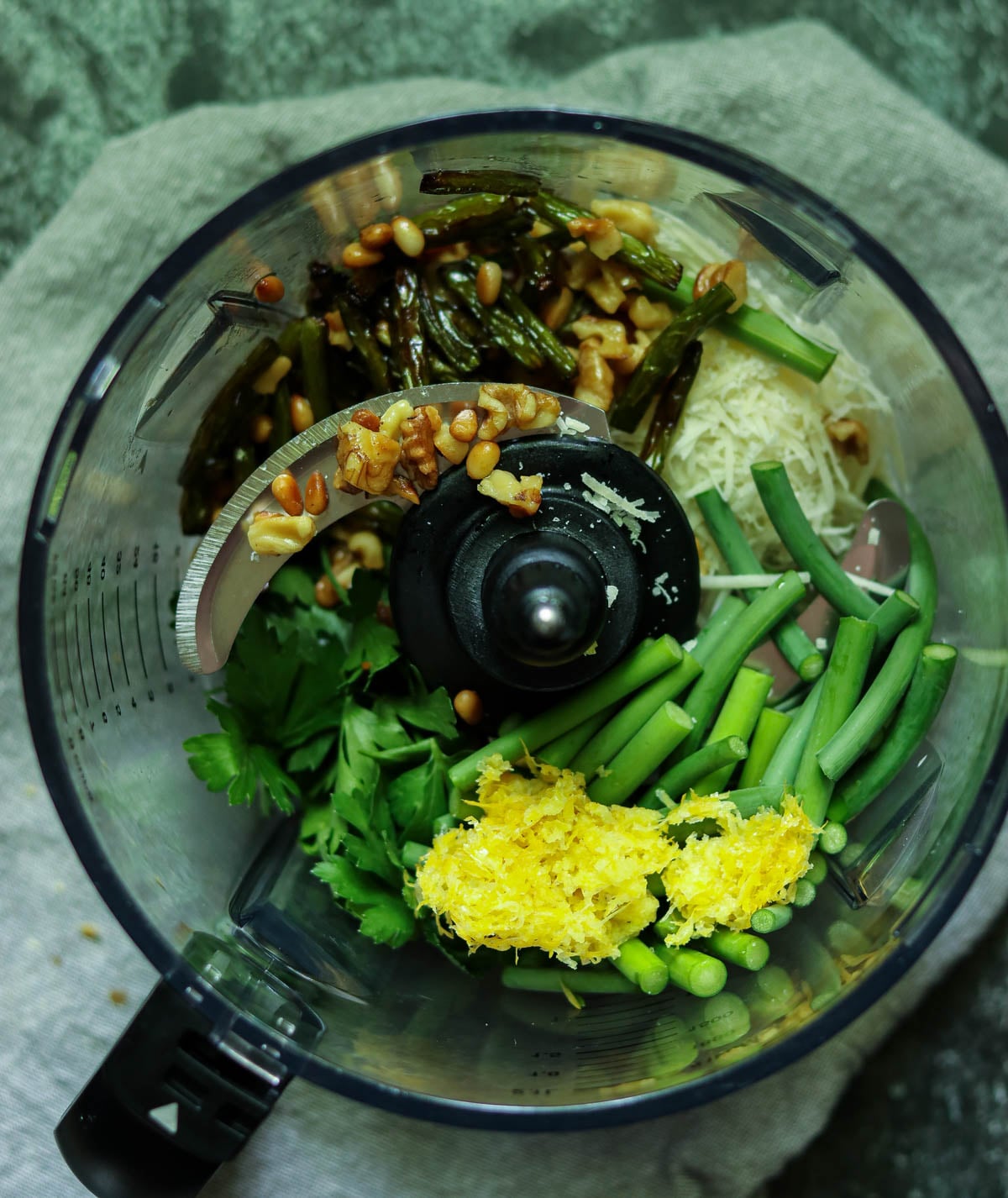 Pesto ingredients in a food processor bowl.