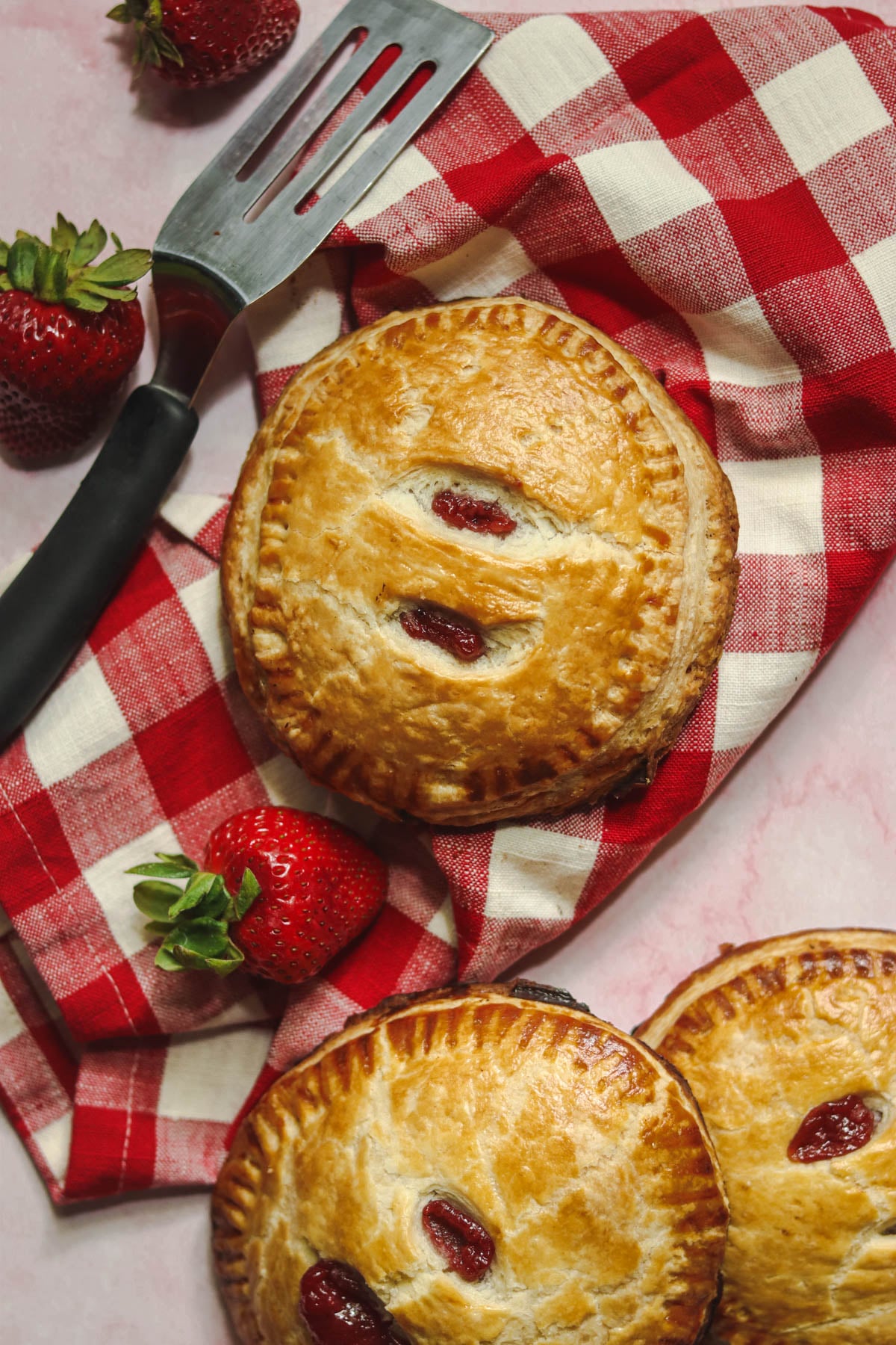 Three hand pies with a spatula.
