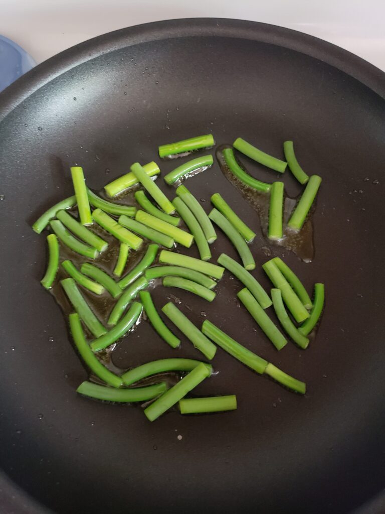 Garl;ic scapes in a pan.