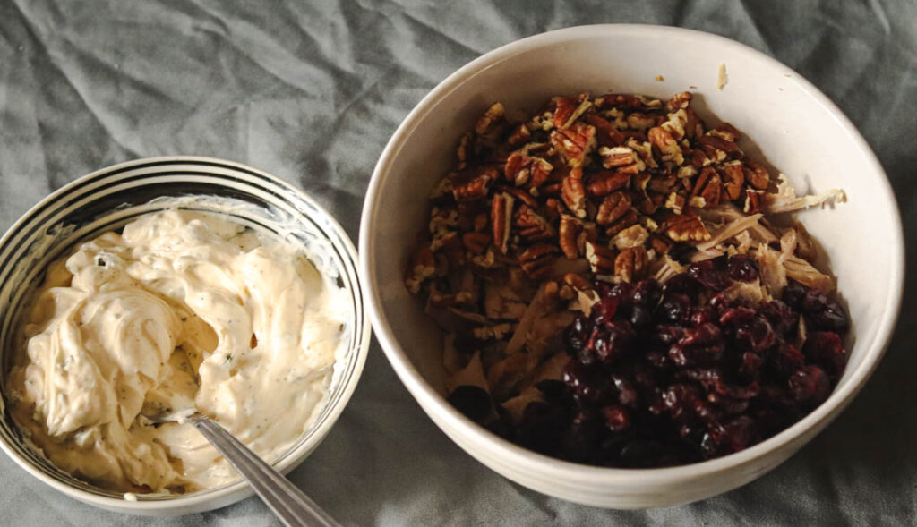 Two bowls with turkey salad ingredients ready to combine together.