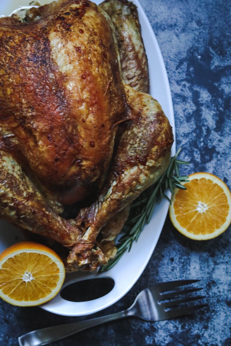 Whole Turkey with a large fork and oranges.