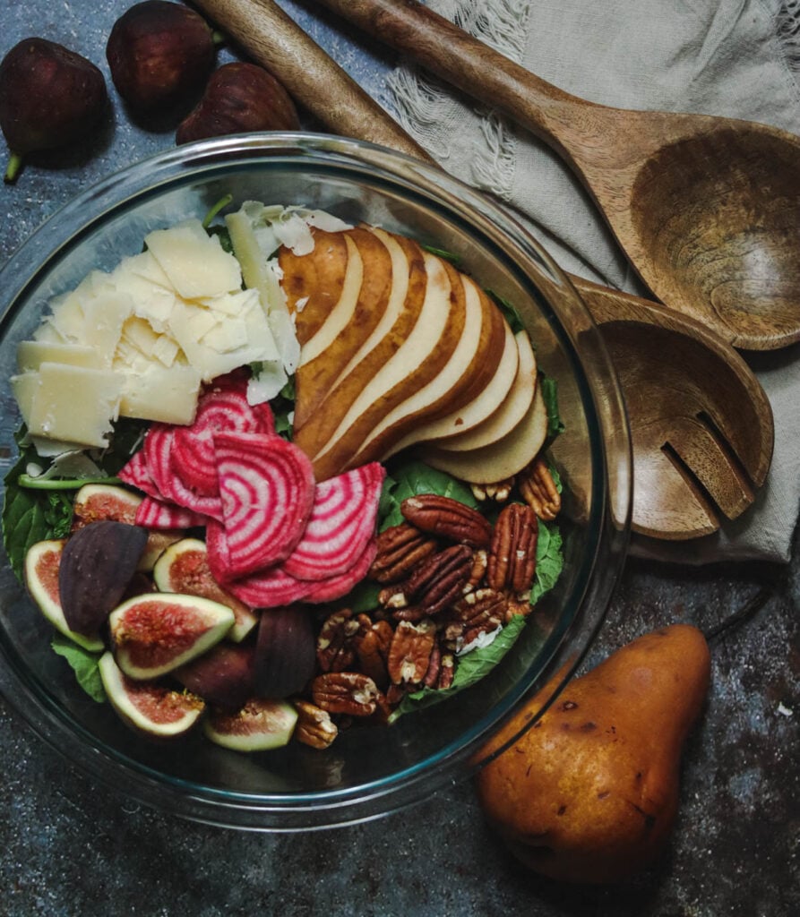 Fall harvest salad with wooden utensils.