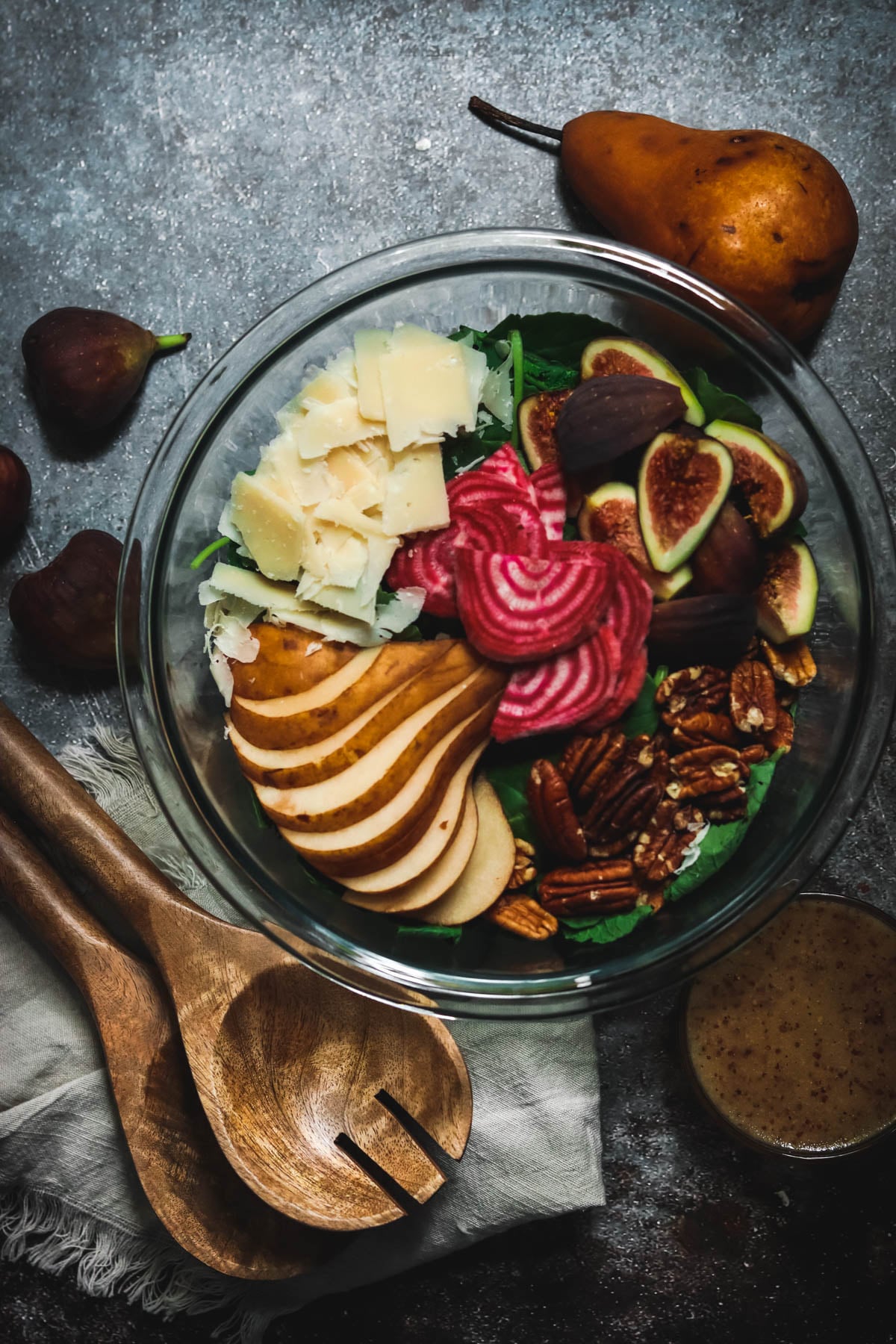 Pear and parmesan salad with beets and pecans in a large bowl.