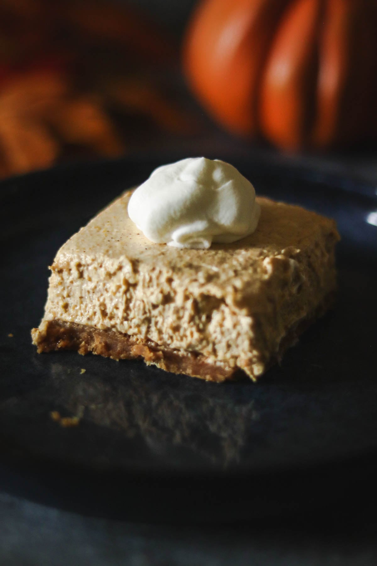 One no bake pumpkin cheesecake bar on a blue plate.