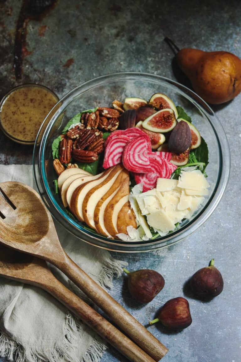 Salad with pears and parmesan in a glass bowl.