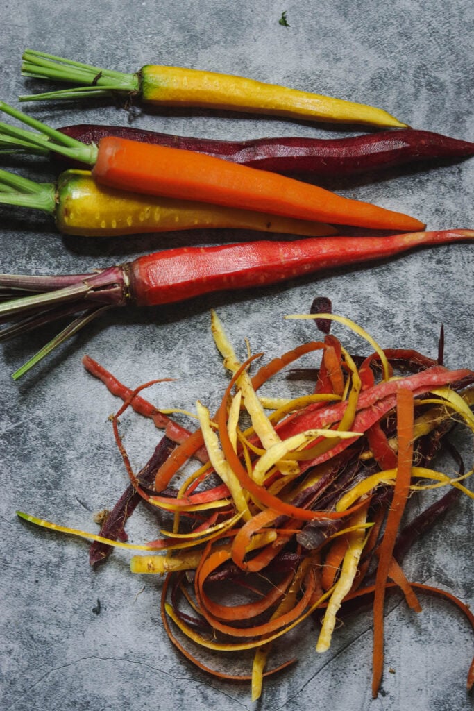 Peeled rainbow carrots and carrot peels.