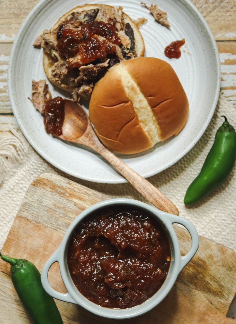Pineapple barbeque sauce in a dish and on a pork sandwich.