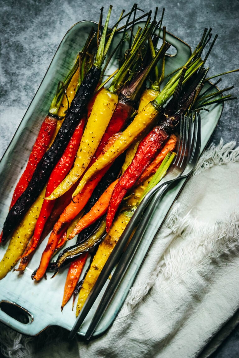 Rainbow carrots that have been roasted next to a white napkin.